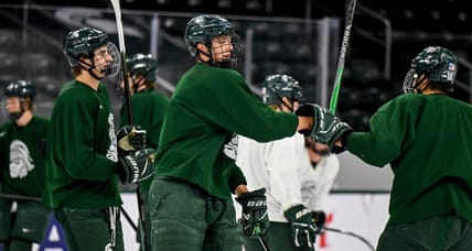 Minnesota Wild top prospect Charlie Stramel, center, bumps fists with Ryker Lee during hockey practice on Thursday, Sept. 25, 2025, at Munn Arena in East Lansing.