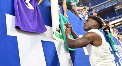 Tyreek Hill - signing Miami Dolphins jersey next to Minnesota Vikings jersey.