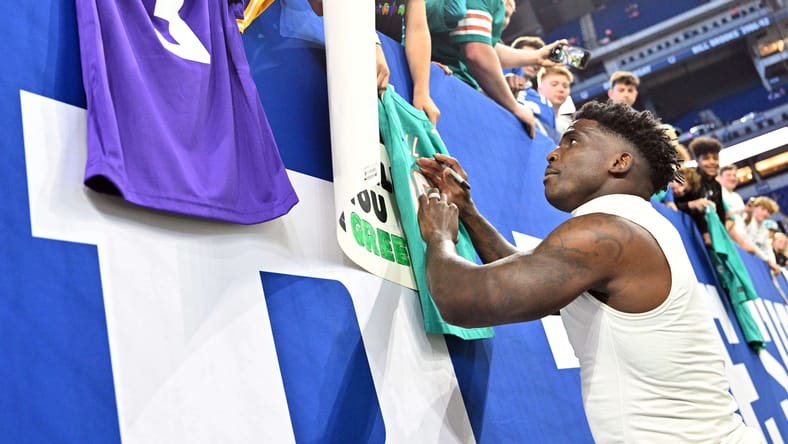 Tyreek Hill - signing Miami Dolphins jersey next to Minnesota Vikings jersey.