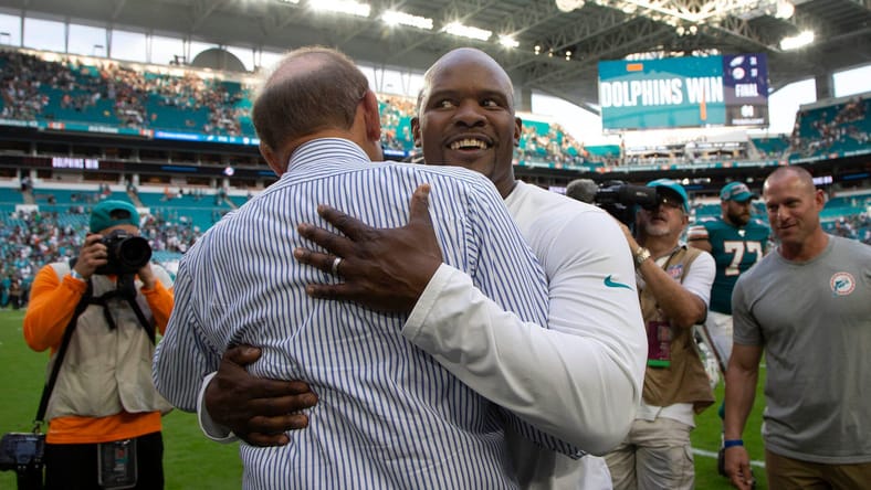 Minnesota Vikings defensive coordinator Brian Flores hugging Miami Dolphins owner Stephen Ross in 2022
