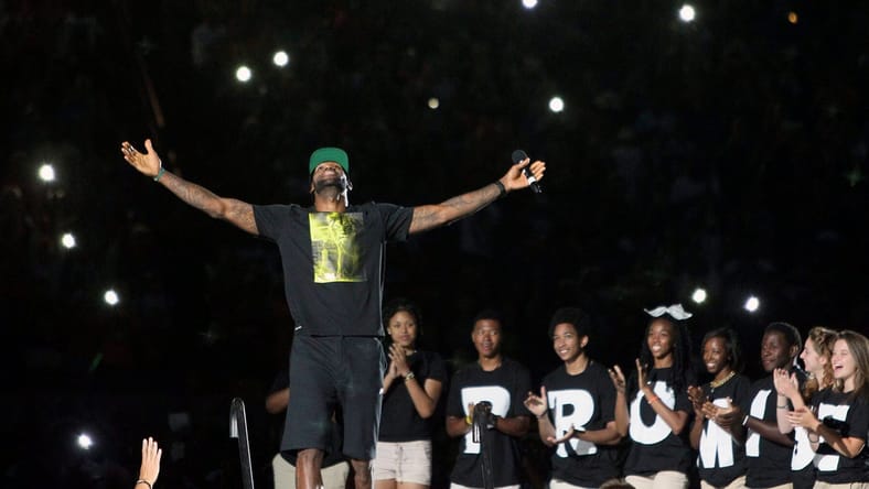 LeBron James acknowledges the crowd's reaction as he takes the stage for the I PROMISE Family Reunion event to welcome him home