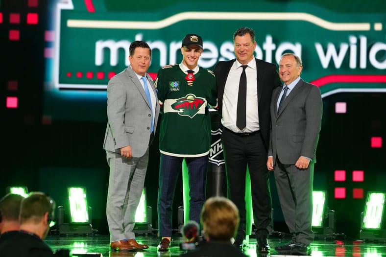 2024 1st round draft pick Zeev Buium on stage at the NHL Draft with Minnesota Wild GM Bill Guerin